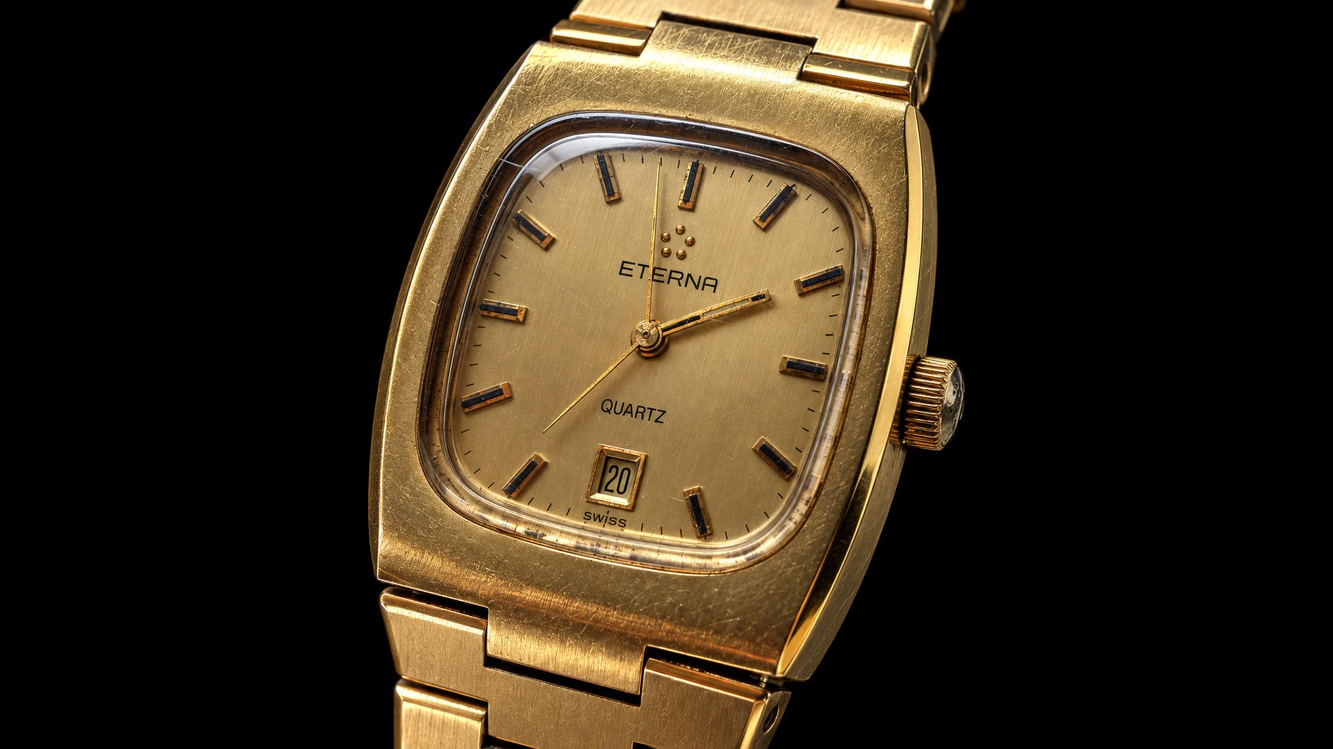 Close-up of the gold dial of a vintage Eterna Quartz watch on a black background