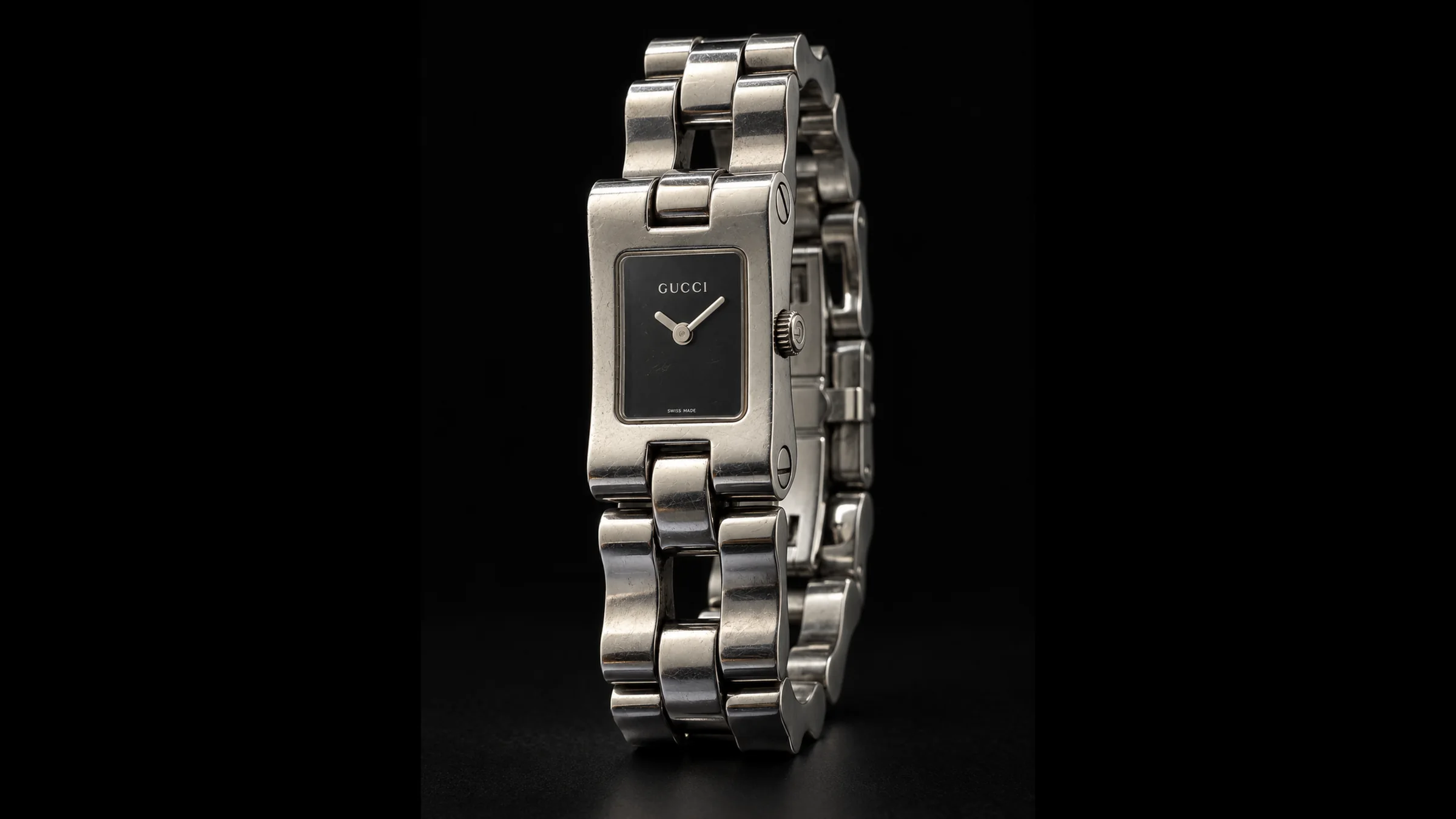 Vue complète de la montre Gucci vintage en acier sur fond noir