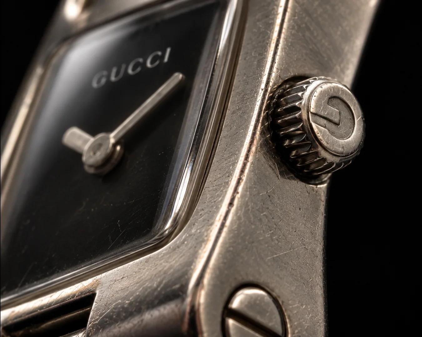 Détail macro de la couronne gravée et du boîtier de la montre Gucci vintage