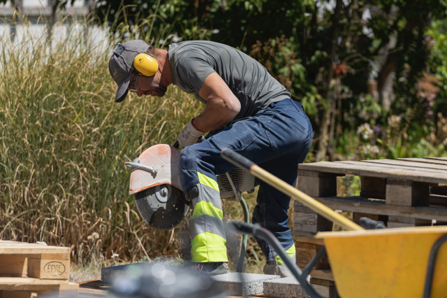 Worker cutting a paving stone on the Horizon Vert site