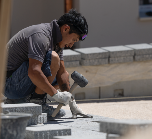 Installer adjusting paving stones with a mallet